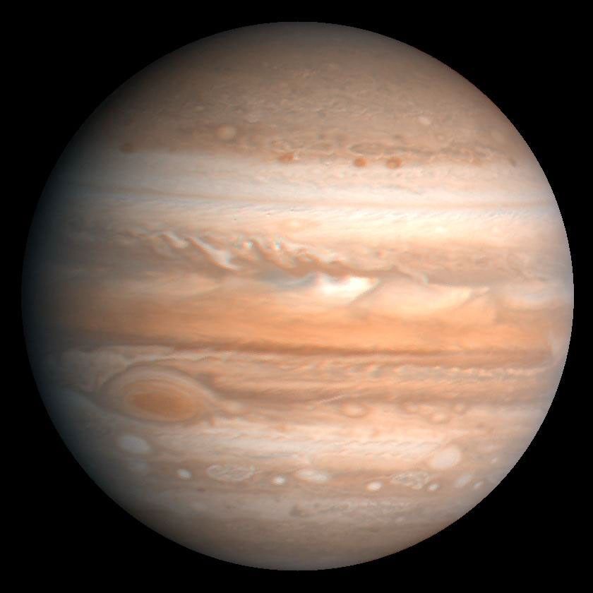 A global view of Jupiter with colorful bands of clouds shrouding the planet.
